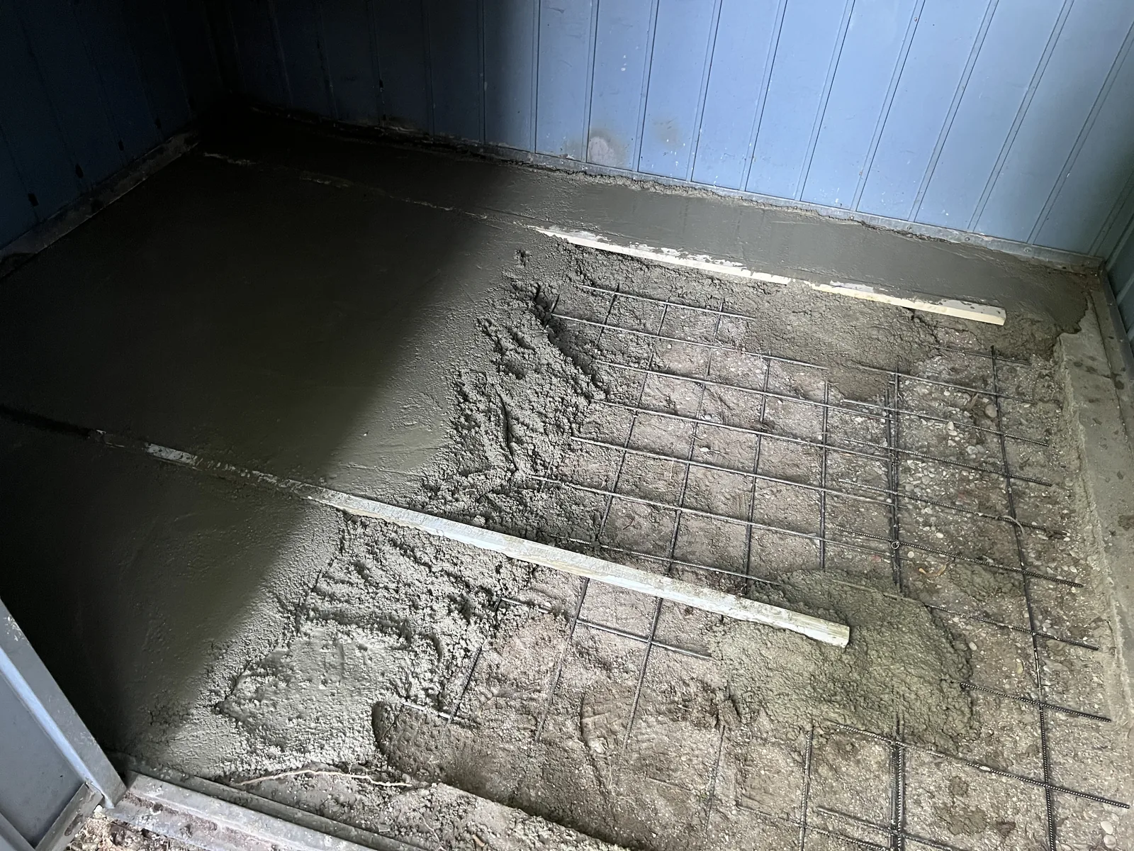 Beton wird in die neue Bodenplatte eingebaut